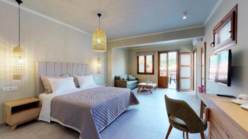 a bedroom with a bed and a desk and a tv at Parga Inn Suites in Parga