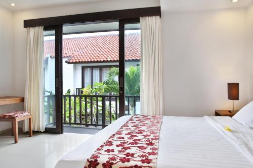 a bedroom with a bed and a balcony at Seminyak TownHouse in Legian