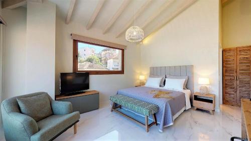 a bedroom with a bed and a chair and a television at Parga Inn Suites in Parga