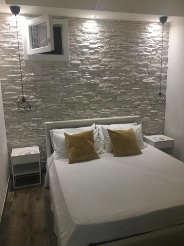 łóżko w pokoju z ceglaną ścianą w obiekcie Peschici Appartamento Vacanze w mieście Peschici