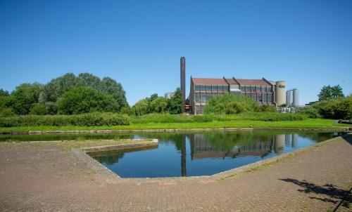 a pond in a park with a building in the background at Lake View Apartment in Northampton