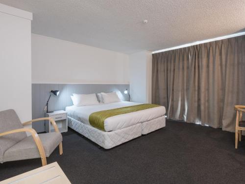a hotel room with a bed and a chair at Queen Street Studios in Richmond