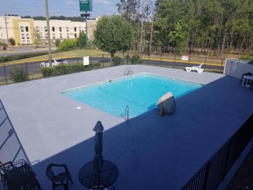 ein großer Pool mit blauer Plane um ihn herum in der Unterkunft America's Best Inn - Macon in Macon
