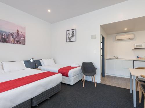 a hotel room with two beds and a desk at Queen Street Studios in Richmond