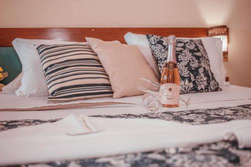 a bed with a bottle of champagne on it at Pousada Recanto da Pedra in Iriri