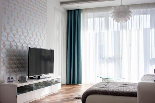 a living room with a flat screen tv and a couch at Center Rev Apartment in Győr
