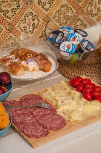 a table topped with cheese and meats and other foods at Borgo Vergini Garden B&B in Naples