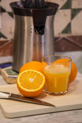 a glass of orange juice next to an orange cut in half at Borgo Vergini Garden B&B in Naples