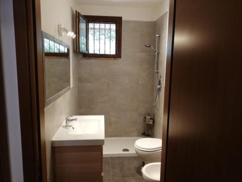 a bathroom with a sink and a toilet and a tub at Appartamento Supramonte in Montemassi
