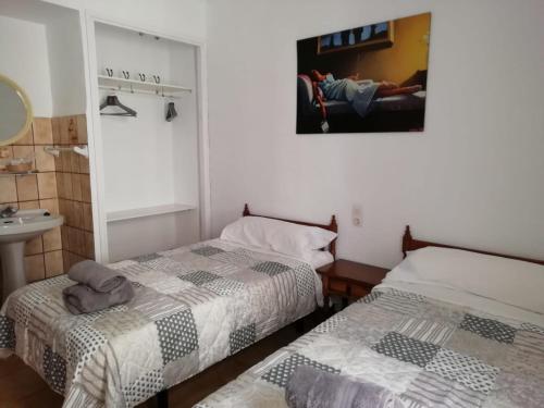 um quarto com 2 camas, um lavatório e um espelho em EL KARMELET em Jalón
