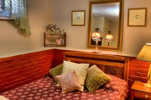 a bedroom with a bed with pillows and a mirror at Bard's Inn in Cedar City