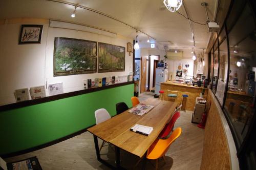 a dining room with a table and a green wall at Asahikawa Ride in Asahikawa