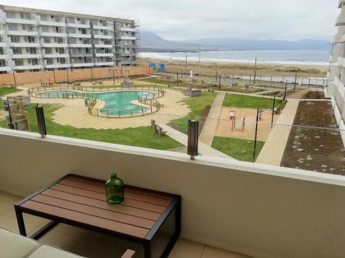 a window with a table and a view of a pool at Moderno departamento, inmejorable vista al mar in Los Molles