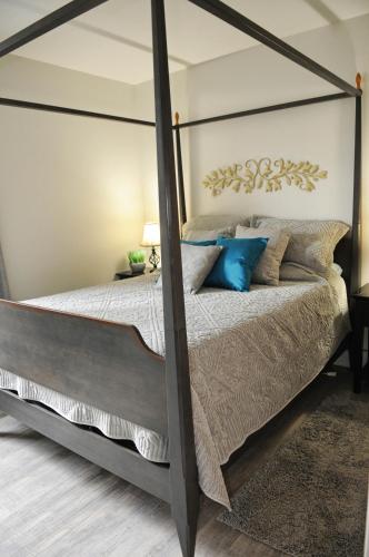 a bedroom with a canopy bed with blue pillows at Valley View in Lake Cowichan