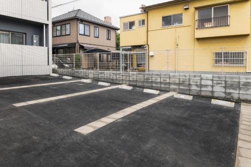 a parking lot in front of two buildings at Cocolie BEPPU in Beppu