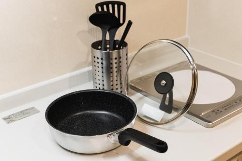 a pot sitting on a stove top next to a strainer at Cocolie BEPPU in Beppu