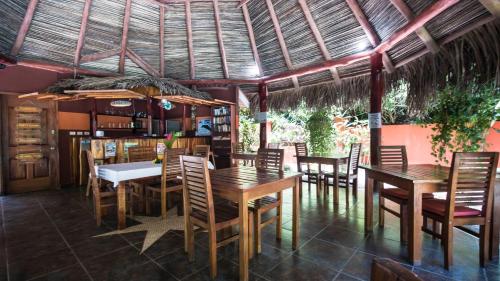 a dining room with wooden tables and chairs at Hotel El Pequeño Gecko Verde in Sámara