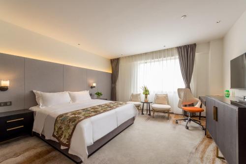 a hotel room with a large bed and a window at Dashen Hotel Shunde Lecong in Shunde