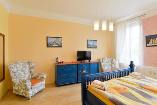 a bedroom with a bed and two chairs and a tv at Pension Ibérica in Brno