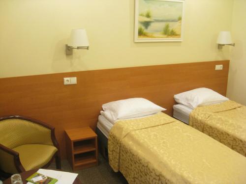 a hotel room with two beds and a chair at Silvija House in Vilnius