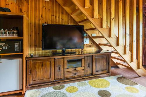 a flat screen tv on a wooden entertainment center in a cabin at Kenting Maya-House B&B in Kenting