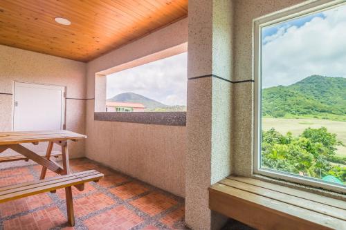 a room with a table and a large window at Kenting Maya-House B&B in Kenting