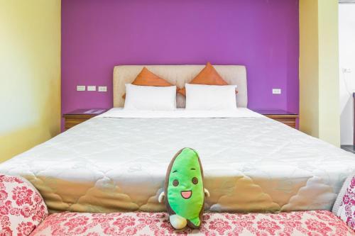 a bedroom with a large bed with a stuffed cucumber on it at Kenting Maya-House B&B in Kenting