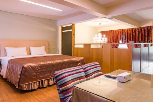 a hotel room with a bed and a table at Kenting Maya-House B&B in Kenting