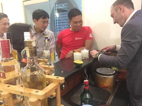 a group of people standing around a table with wine bottles at Chau Pho Hotel in Chau Doc