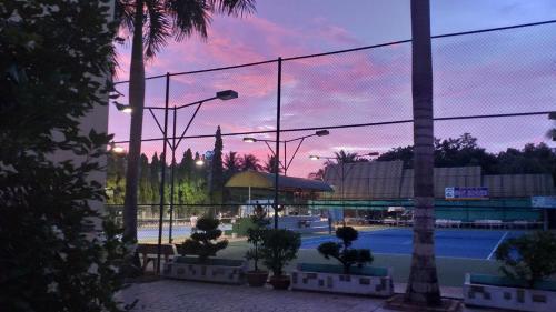 朱篤的住宿－Chau Pho Hotel，日落时分享有网球场的景致