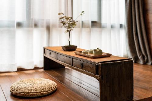 a wooden table with a plant on top of it at Xi'an Travelling with Hotel South Gate in Xi'an