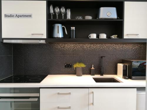 a kitchen with white cabinets and a black wall at Private apartments in a Landmark Heritage Building in Auckland