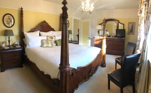 a bedroom with a large bed and a chair at The Inn on Knowles Hill Bed & Breakfast Hotel in Sonora