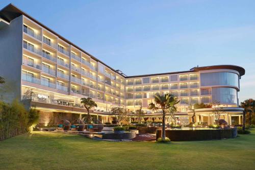 a large hotel building with a lawn in front of it at Swiss-Belresort Pecatu in Uluwatu