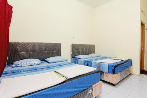 two beds in a room withthritisthritislictslictslicts at Hotel Wijaya 2 Kaliurang in Yogyakarta