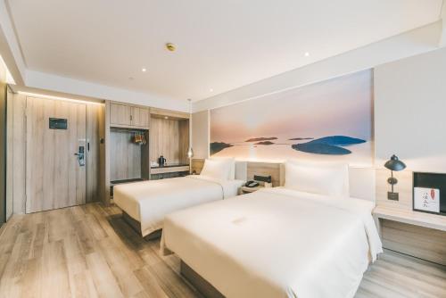 two beds in a hotel room at Atour Hotel Changshu Changjiang Road Branch in Changshu