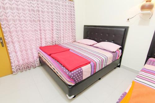 a small bed in a room with pink pillows at Hotel Wijaya 2 Kaliurang in Yogyakarta