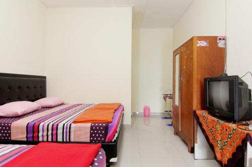 a bedroom with two beds and a tv in it at Hotel Wijaya 2 Kaliurang in Yogyakarta
