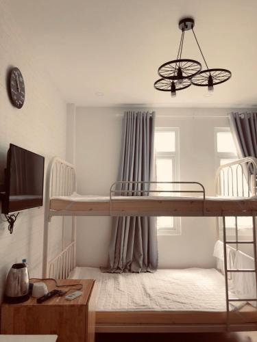 a bedroom with a bunk bed and a chandelier at Sele House in Ha Tien