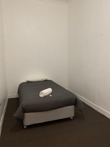 a bed with a white pillow on top of it at Garden Hotel in Dubbo