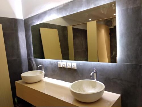 a bathroom with two sinks and a large mirror at XOXO Kuta Legian Hostel in Legian