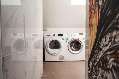 a washing machine and a washer and dryer in a bathroom at VALIZA HOSTEL in Uzhhorod