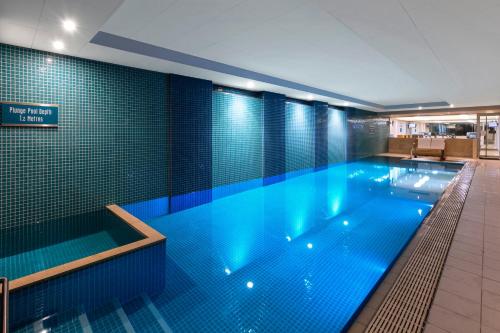 a large swimming pool in a large building at Apartments @ 16 Holdfast in Glenelg