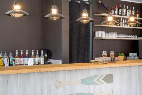a bar with bottles and glasses of wine at Best Western Plus Antibes Riviera in Antibes