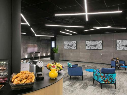 a lobby with a counter with a bowl of bread at Mercure Bordeaux Aéroport in Mérignac
