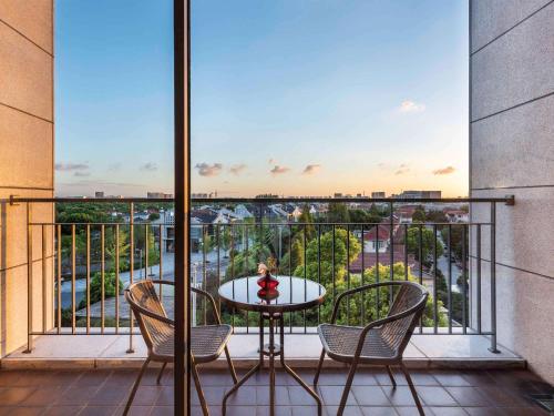 a balcony with a table and chairs and a view at Novotel Suites Shanghai Hongqiao in Shanghai