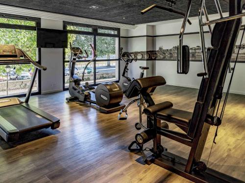 a gym with treadmills and exercise equipment in a room at Hotel Mercure Blois Centre in Blois