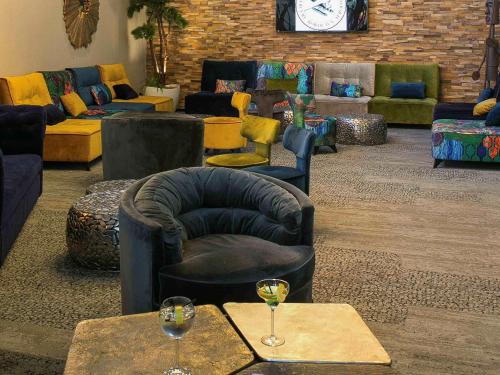 a living room with couches and glasses of wine at Mercure Bordeaux Aéroport in Mérignac