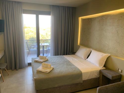 a bedroom with a bed with two towels on it at Castella Apartments in Vourvourou