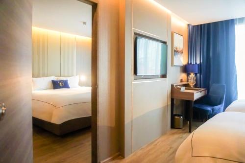 a hotel room with a bed and a mirror at GLOW Sukhumvit 5 in Bangkok